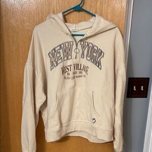 Modish Rebel: Cream Hoodie with New York  SoHo slogan. Quarter Zip. Large.